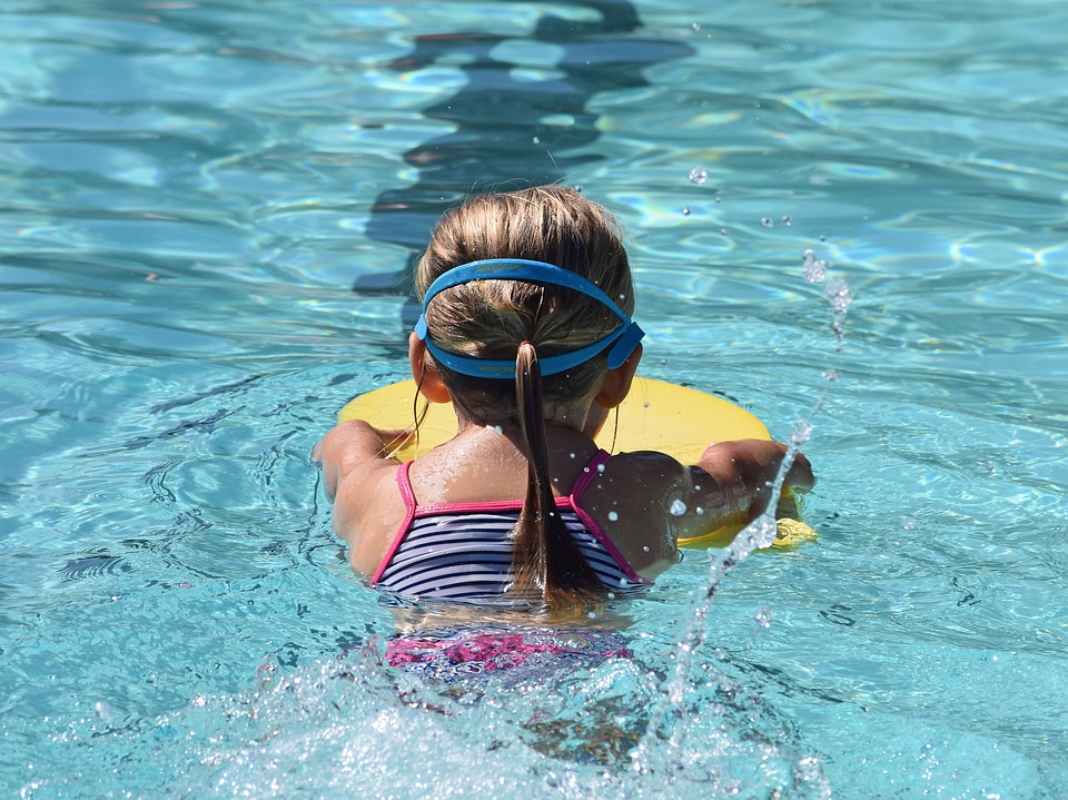Photo enfant apprenant à nager dans une piscine